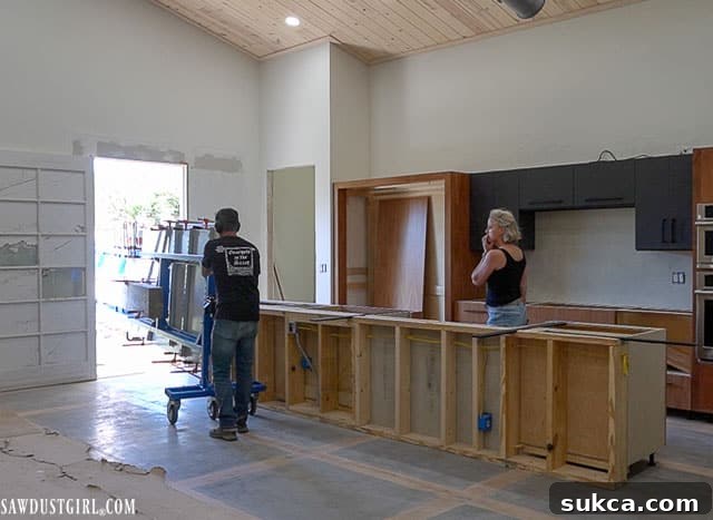 Large concrete countertop slab carefully being moved into the kitchen of a second-story lodge.
