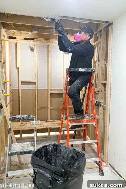Initial stages of bathroom renovation, showing wall framing and plumbing rough-ins.