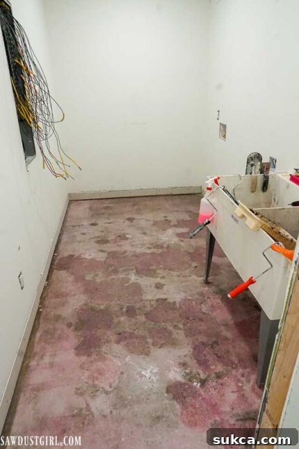 The laundry room in its early renovation stage, showing wall preparation and open space.