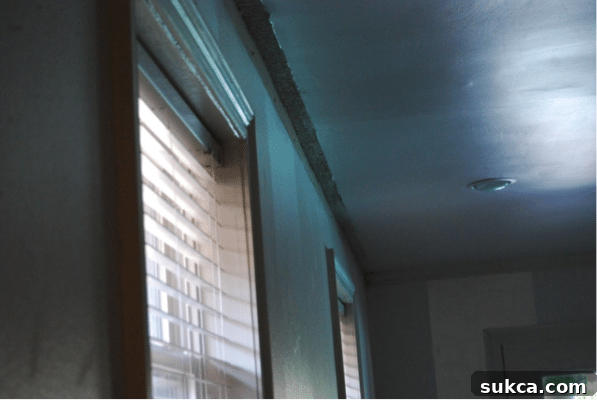 Removing old crown molding reveals a vintage popcorn ceiling and hidden wall textures