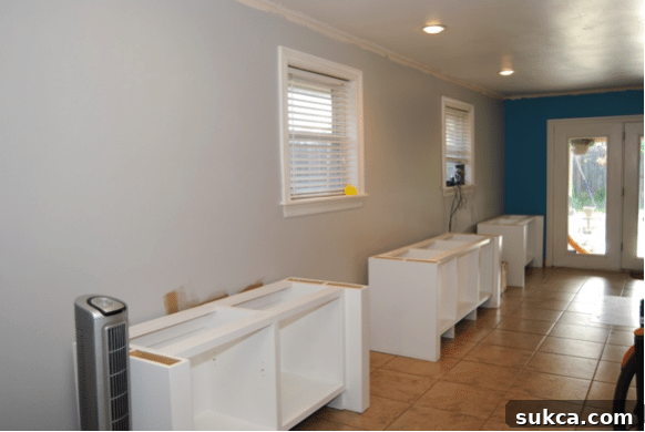 Custom built-in cabinets being moved into place against freshly painted walls