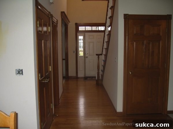 Illinois entry hallway before renovation, showing worn flooring and outdated lighting