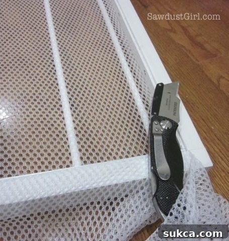 Trimming excess netting from the drying rack with a utility knife.